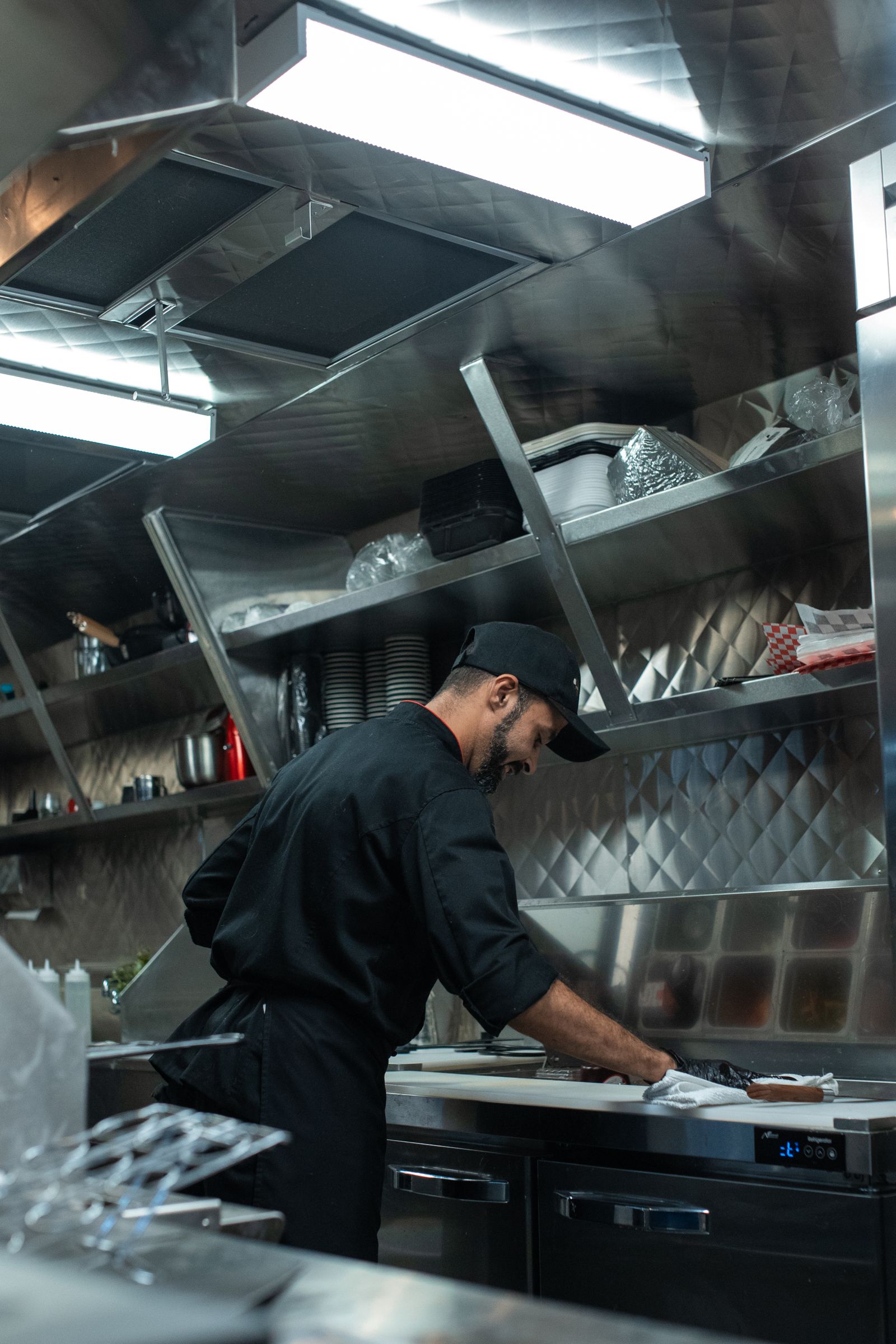 Cozinha profissional com bancadas e hotte em aço inox