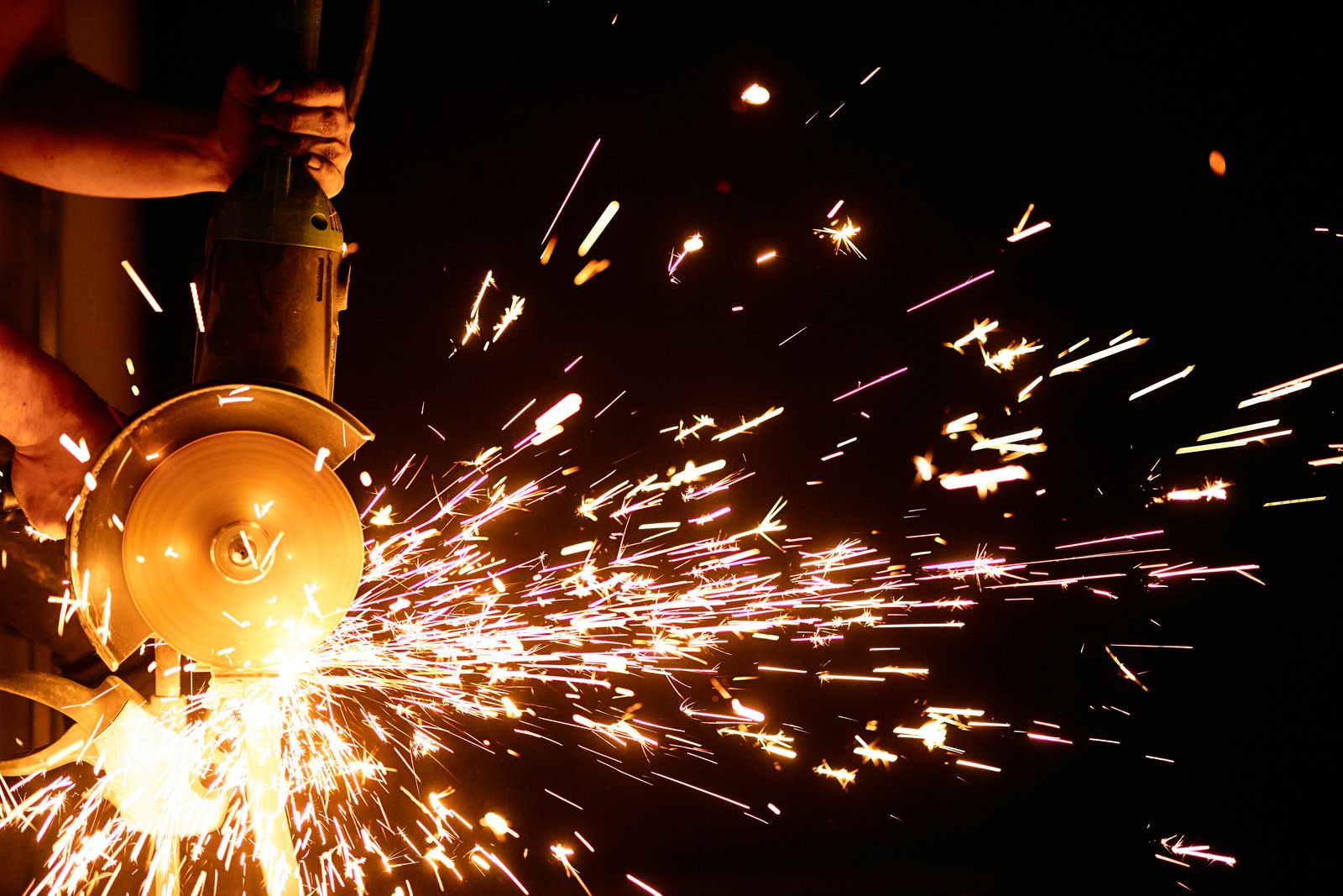 Faíscas de rebarbadora a cortar metal em grande plano